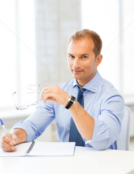 Biznesmen okulary piśmie notebooka zdjęcie przystojny Zdjęcia stock © dolgachov
