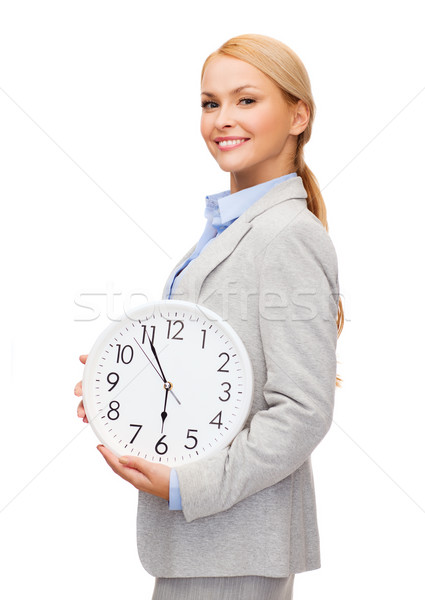 smiling businesswoman with wall clock Stock photo © dolgachov