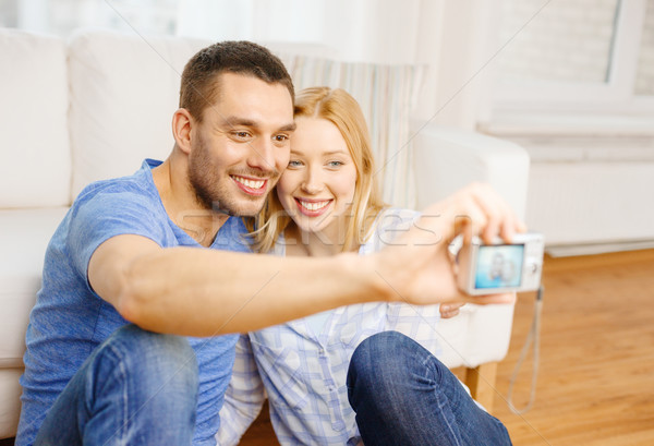 smiling couple taking picture with digital camera Stock photo © dolgachov