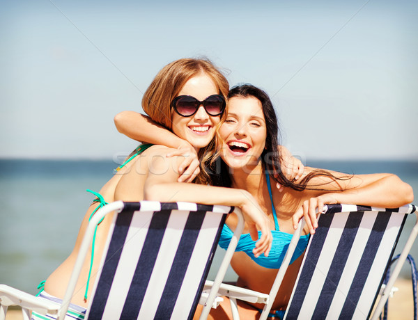 girls sunbathing on the beach chairs Stock photo © dolgachov