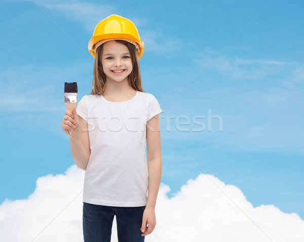 smiling little girl in helmet with paint roller Stock photo © dolgachov