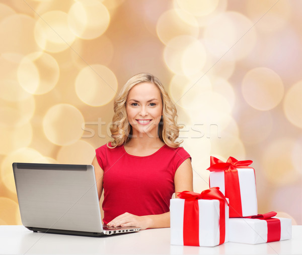 smiling woman in red shirt with gifts and laptop Stock photo © dolgachov