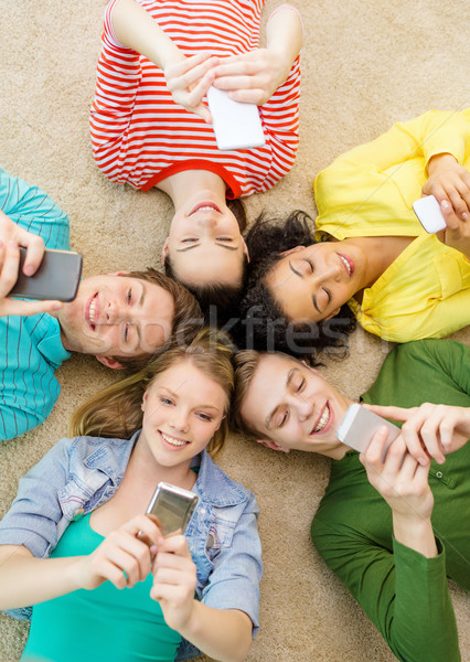 Stock photo: group of smiling people lying down on floor