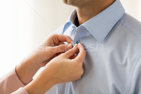 close up of man and woman fastening shirt buttons Stock photo © dolgachov