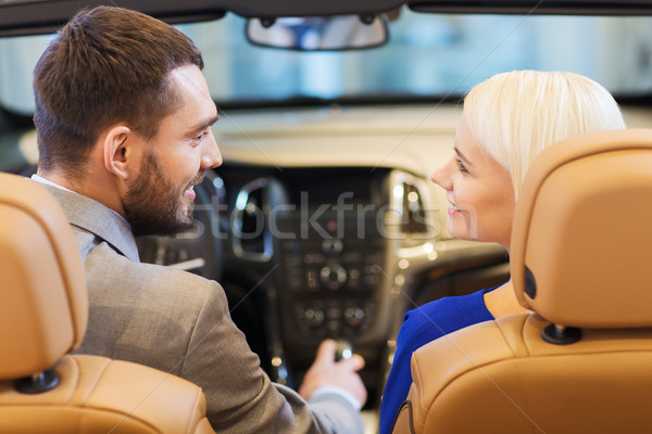 happy couple sitting in car at auto show or salon Stock photo © dolgachov