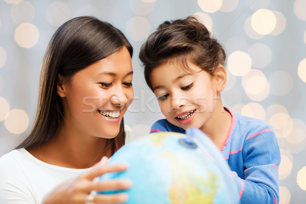 happy mother and daughter with globe Stock photo © dolgachov