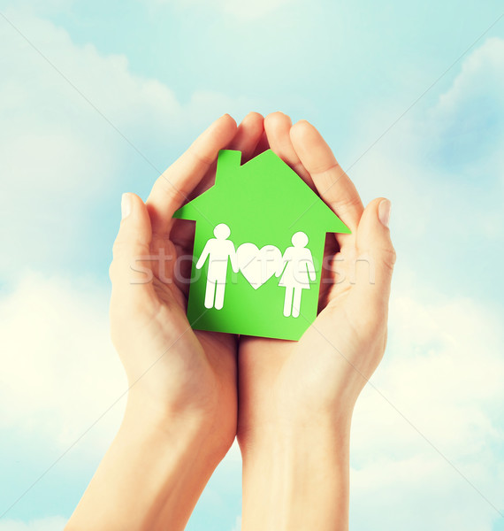 hands holding green house with family Stock photo © dolgachov