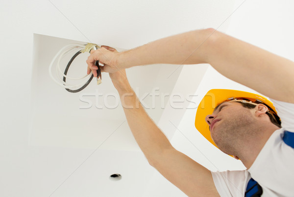 close up of builder or electrician running wires Stock photo © dolgachov