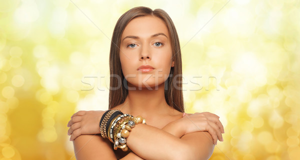 beautiful woman with bracelets over yellow lights Stock photo © dolgachov