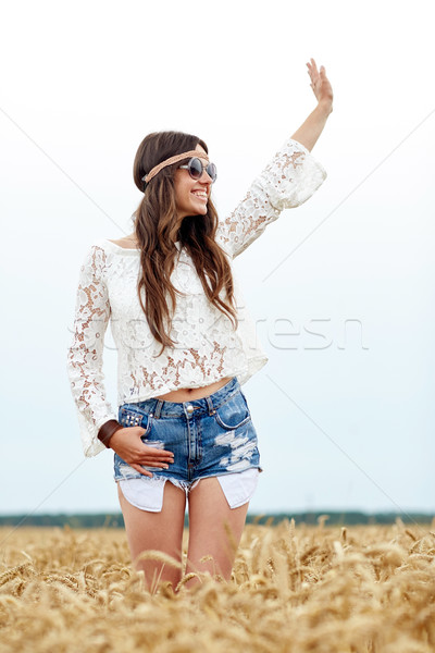 Stock photo: smiling hippie woman on cereal field waving hand