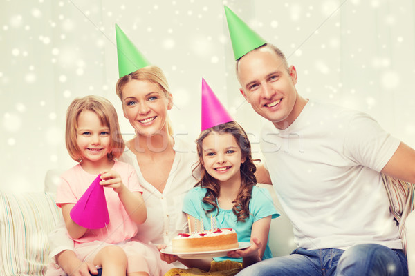 Stock photo: happy family with two kids in party hats at home