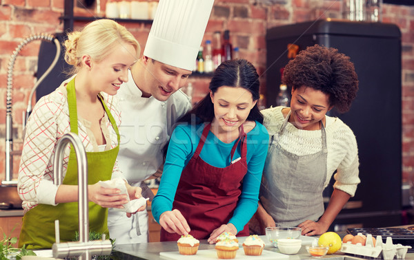 happy women and chef cook cooking in kitchen Stock photo © dolgachov