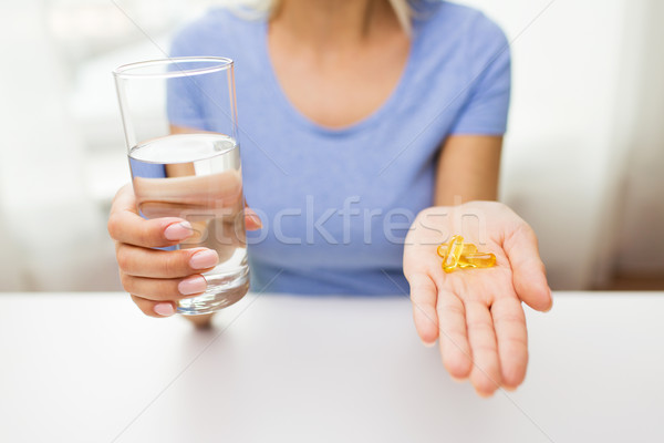 close up of woman hands with capsules and water Stock photo © dolgachov
