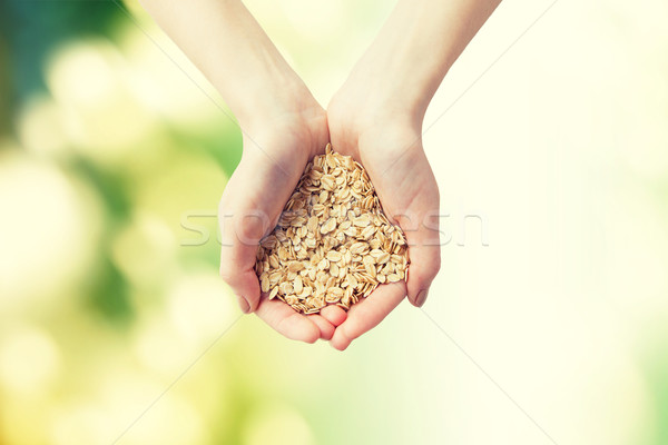 close up of woman hands holding oatmeal flakes Stock photo © dolgachov