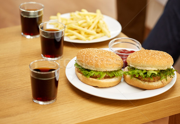 close up of fast food and drinks on table at home Stock photo © dolgachov