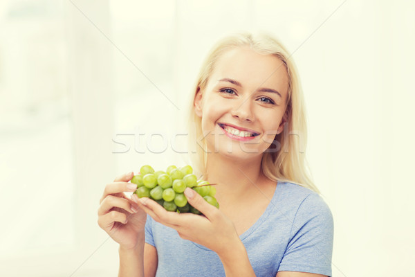 Boldog nő eszik szőlő otthon egészséges étkezés Stock fotó © dolgachov