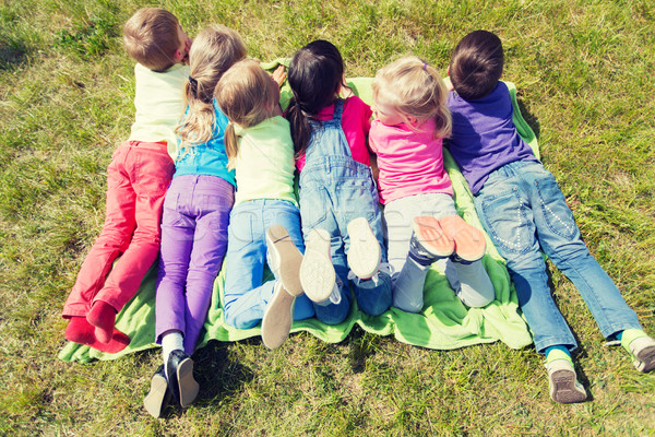 group of kids lying on blanket or cover outdoors Stock photo © dolgachov