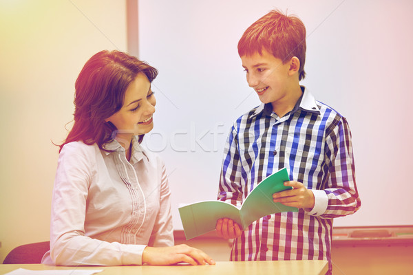 school boy with notebook and teacher in classroom Stock photo © dolgachov