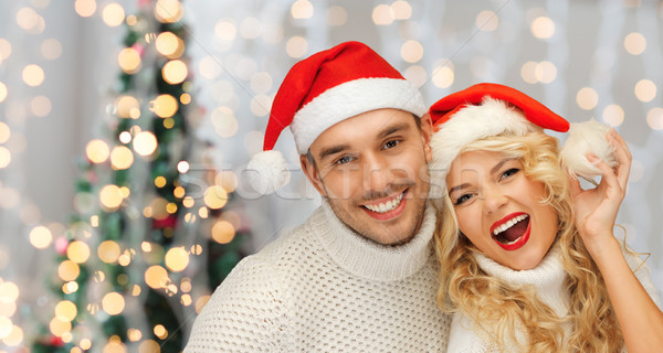 happy family couple in sweaters and santa hats Stock photo © dolgachov