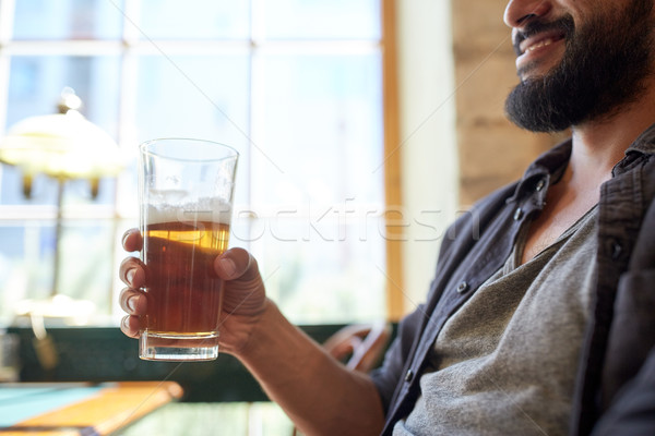 close up of happy man drinking beer at bar or pub Stock photo © dolgachov