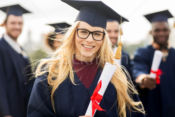Stock photo: happy students in mortar boards with diplomas