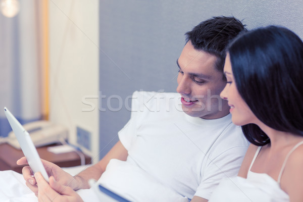 smiling couple in bed with tablet pc computers Stock photo © dolgachov