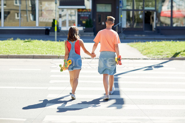 teenage couple with skateboards on city crosswalk Stock photo © dolgachov