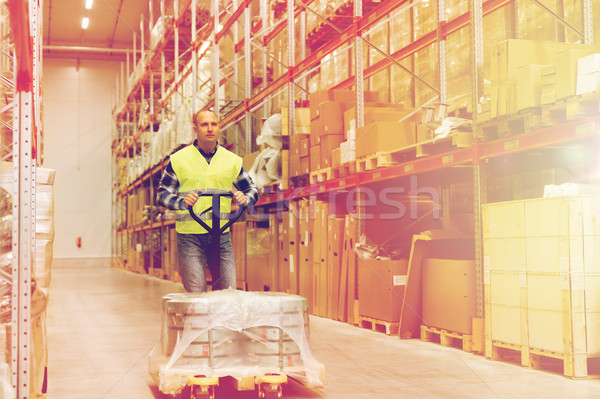 man carrying loader with goods at warehouse Stock photo © dolgachov