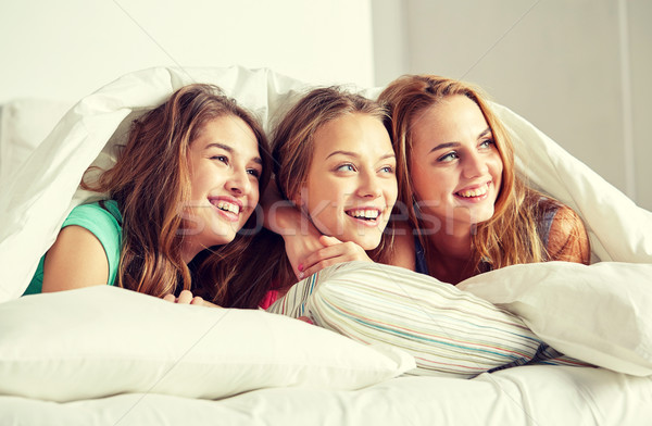 happy young women in bed at home pajama party Stock photo © dolgachov