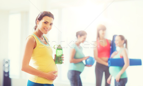 Heureux femme enceinte une bouteille d'eau gymnase grossesse sport [[stock_photo]] © dolgachov