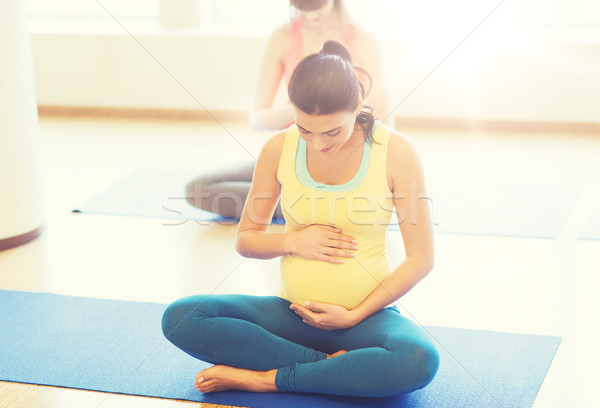 happy pregnant women exercising yoga in gym Stock photo © dolgachov