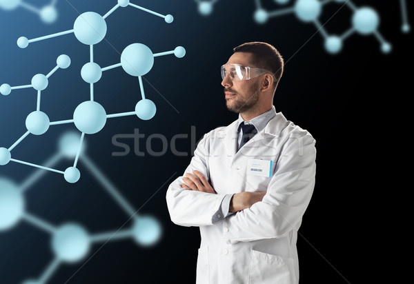 scientist in lab coat and goggles with molecules Stock photo © dolgachov