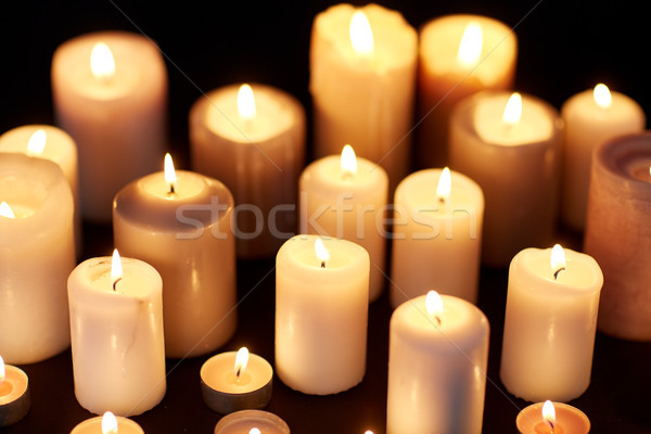 candles burning in darkness over black background Stock photo © dolgachov