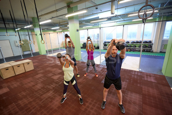 group of people with kettlebells exercising in gym Stock photo © dolgachov