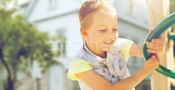 Stock photo: happy little girl climbing on children playground