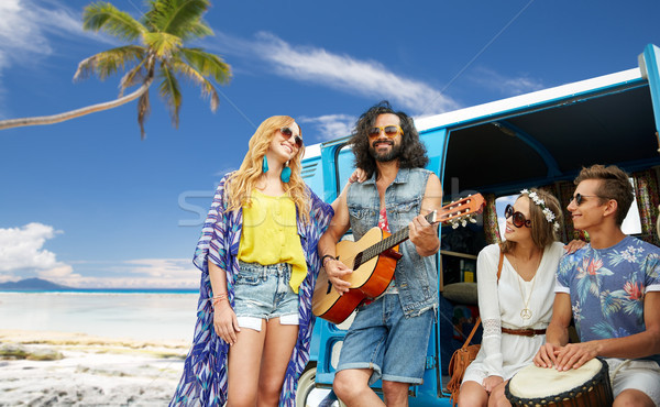 hippie friends playing music over minivan on beach Stock photo © dolgachov