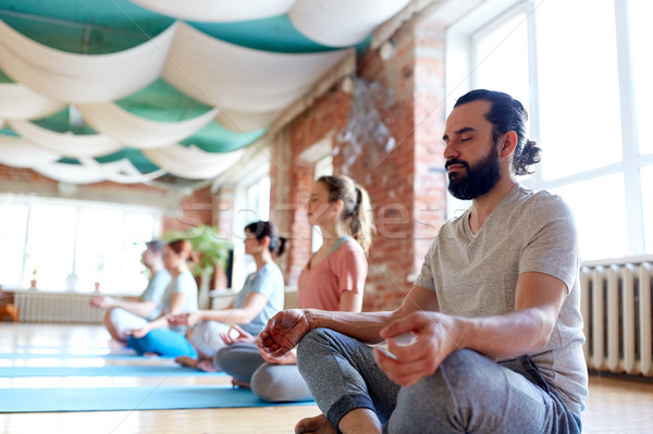 man with group of people meditating at yoga studio Stock photo © dolgachov