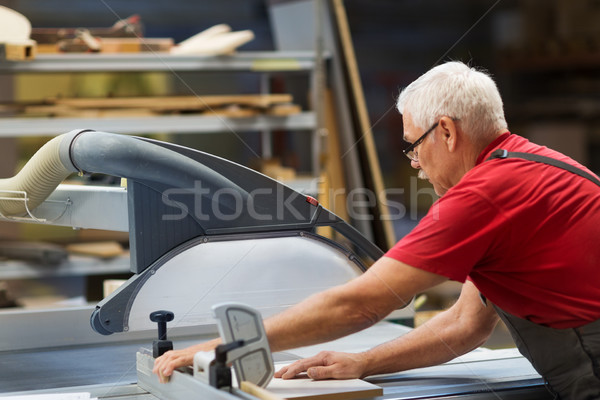 carpenter with panel saw and fibreboard at factory Stock photo © dolgachov
