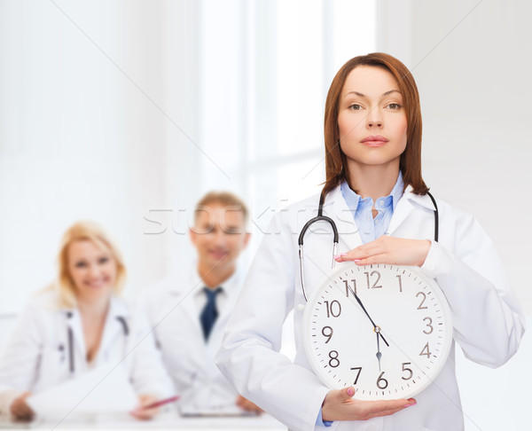 calm female doctor with wall clock Stock photo © dolgachov