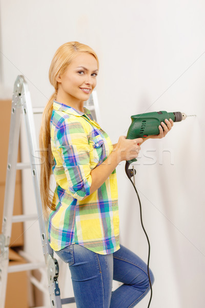 Kobieta elektryczne wiercenia otwór ściany Zdjęcia stock © dolgachov