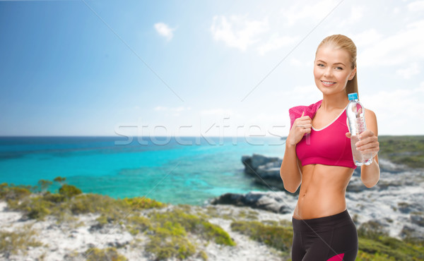 sporty woman with bottle of water and towel Stock photo © dolgachov