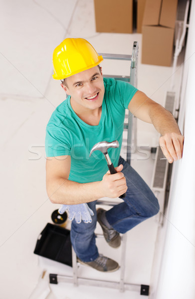 Glimlachend man helm nagel muur reparatie Stockfoto © dolgachov