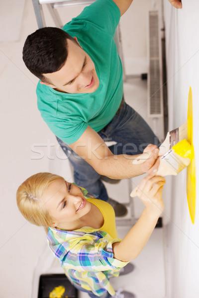 smiling couple painting wall at home Stock photo © dolgachov