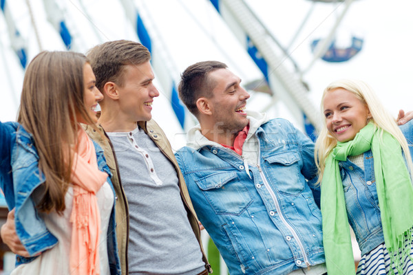 group of smiling friends in amusement park Stock photo © dolgachov