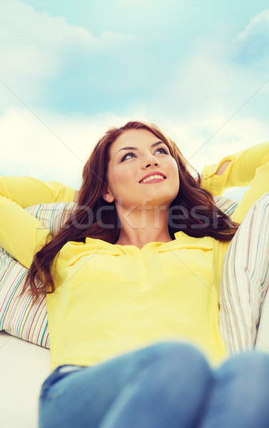 Stock photo: smiling young woman lying on sofa at home