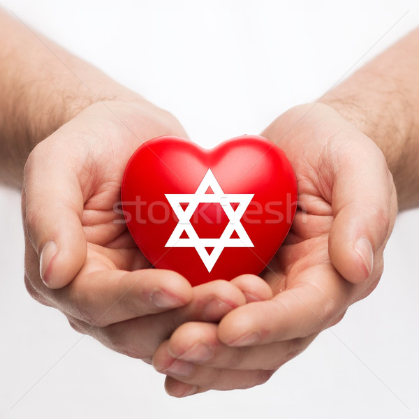 male hands holding heart with star of david Stock photo © dolgachov