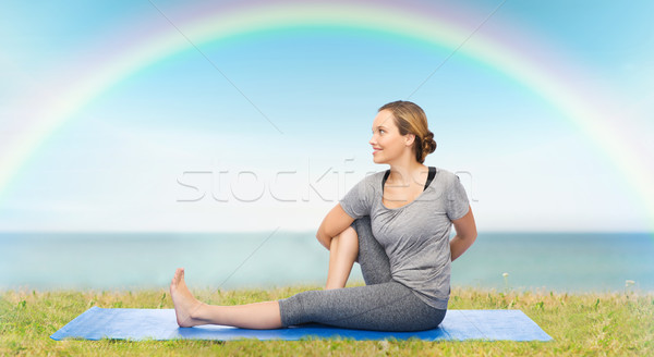 woman making yoga in twist pose on mat Stock photo © dolgachov