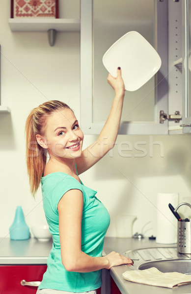 Szczęśliwy kobieta tablicy szafki kuchenne ludzi prace domowe Zdjęcia stock © dolgachov
