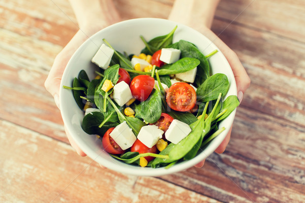 close up of young woman hands showing salad bowl Stock photo © dolgachov