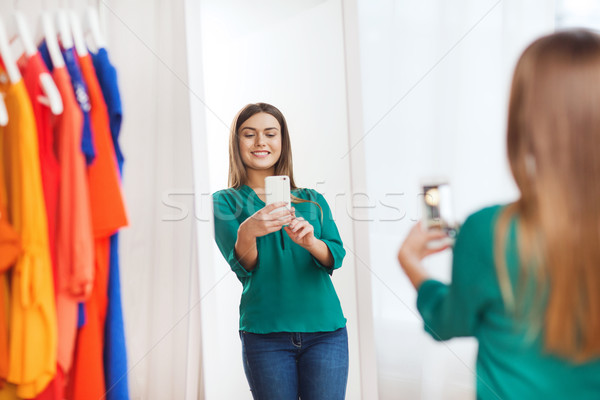 woman with smartphone taking mirror selfie at home Stock photo © dolgachov